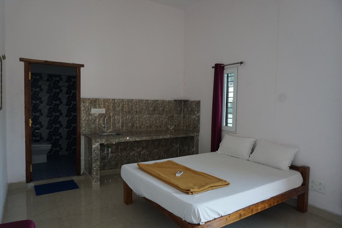 Prithvi room G1, Art Le Cafe Auroville — bed and en-suite bathroom entrance